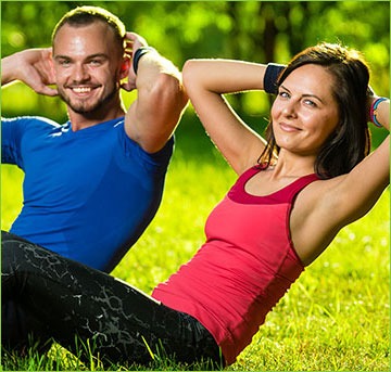 Couple Doing Situps in the Grass